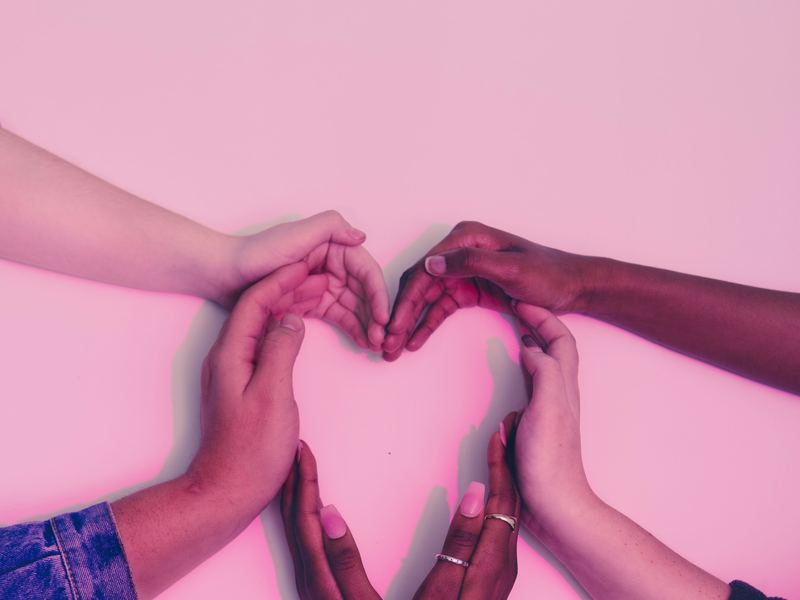 Grupo de manos formando un corazón